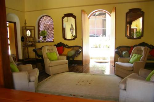 Lounge area having large white cushioned sofas and natural light coming in through a main door