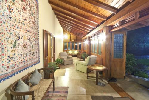 A view on a rainy night from the verandah containing sitting furniture and showing a wall hanging on the left