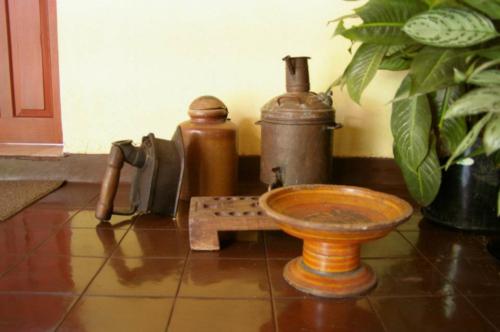 Antique household utensils including a hot-water-powered clothes iron